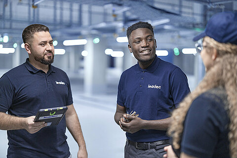 Leadec team talking in factory.